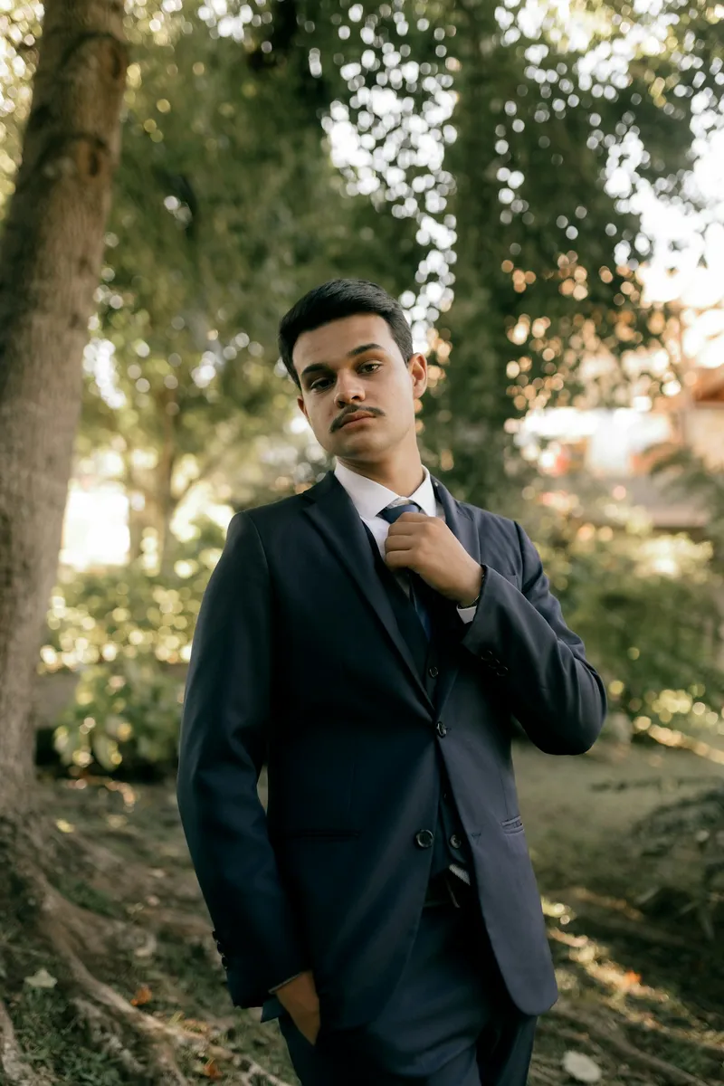 Mire ajustându-și cravata, costum bleumarin, ținută outdoor